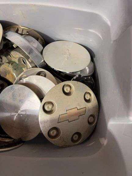 Tote of Chevy hub caps and parts