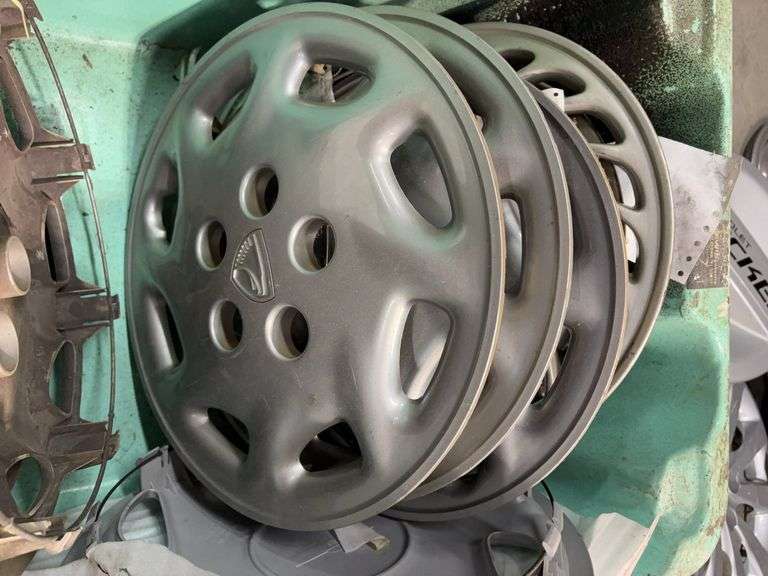 Large tote of Nissan hub caps and parts