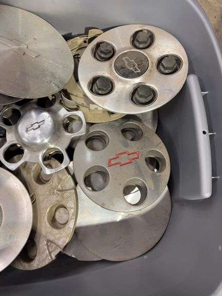 Tote of Chevy hub caps and parts