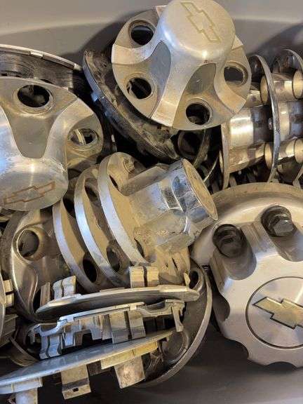 Large tote of Chevy hub caps and parts