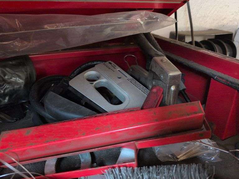 Assortment of tools - battery charger, staple gun, sockets, and more