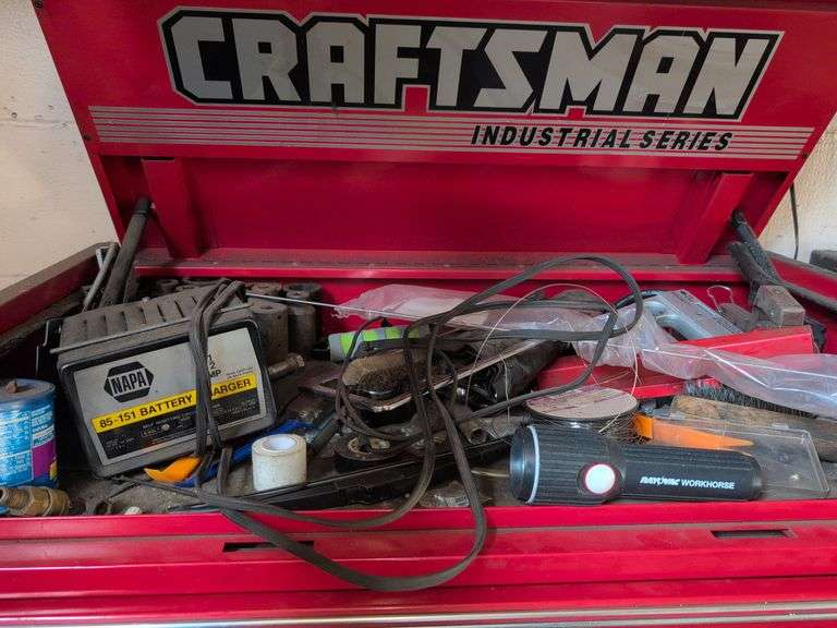 Assortment of tools - battery charger, staple gun, sockets, and more