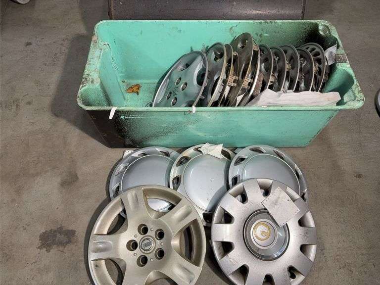 Large tote of Nissan hub caps and parts