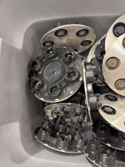 Tote of Chevy hub caps and parts