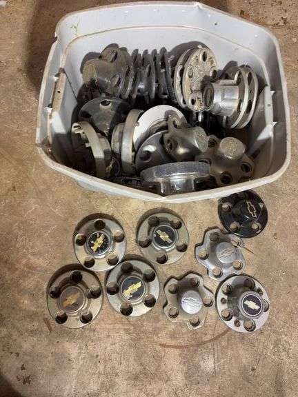 Tote of Chevy hub caps and parts