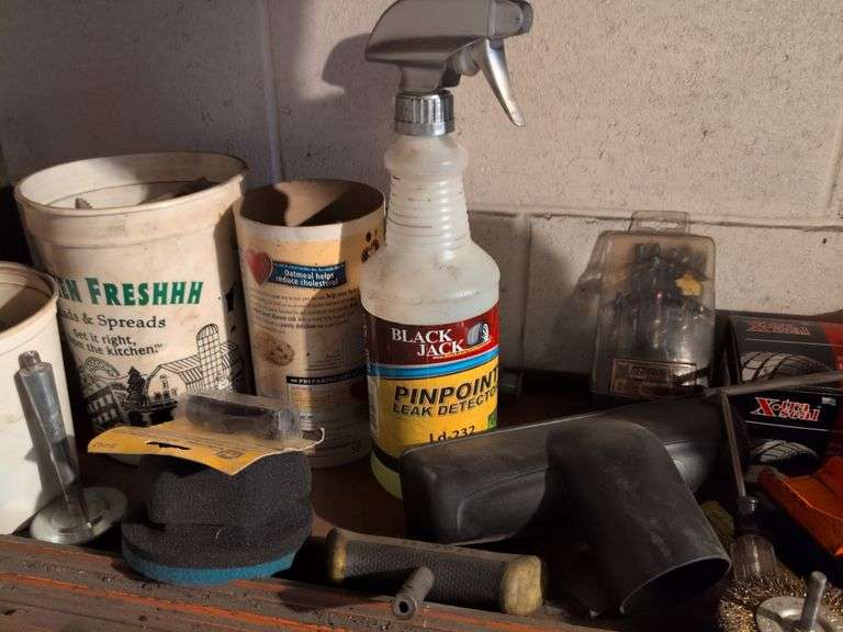 Shelf of drill bits, wire grinder, toy Tonka truck, and more