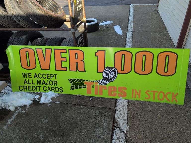 Large double-sided green metal sign - "Over 1000 tires in stock" - 8' x 28"