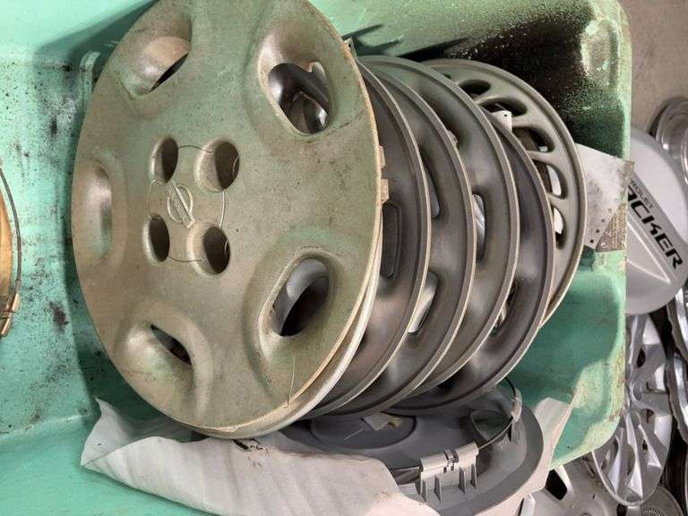 Large tote of Nissan hub caps and parts
