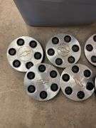 Tote of Chevy hub caps and parts