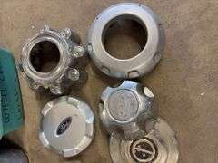 Tote of Ford hub caps and parts and small tote of Wheel cover locks