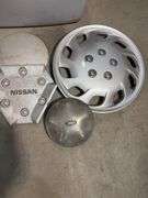 Tote of hub caps and parts -Nissan, Chevy, Ford and more