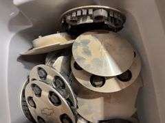 Tote of Chevy hub caps and parts
