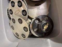 Tote of Chevy hub caps and parts