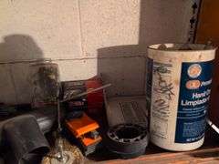 Shelf of drill bits, wire grinder, toy Tonka truck, and more