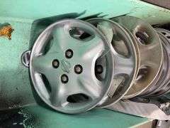 Large tote of Nissan hub caps and parts