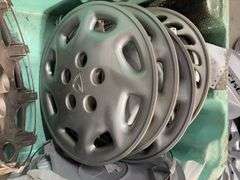 Large tote of Nissan hub caps and parts