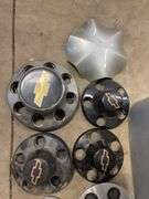 Tote of Chevy hub caps and parts