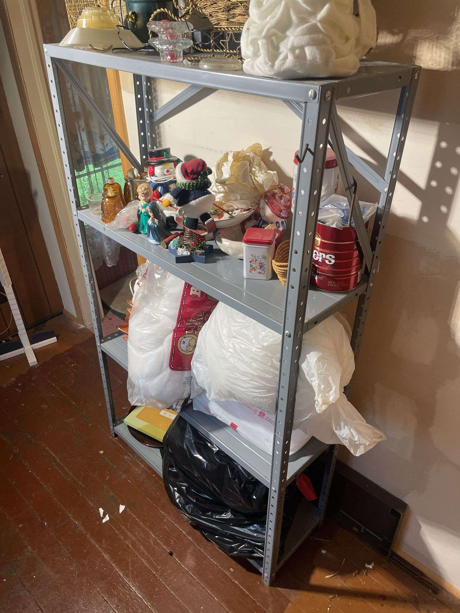Metal shelf with Christmas decor including decorative sleigh, figurines, stuffing and more