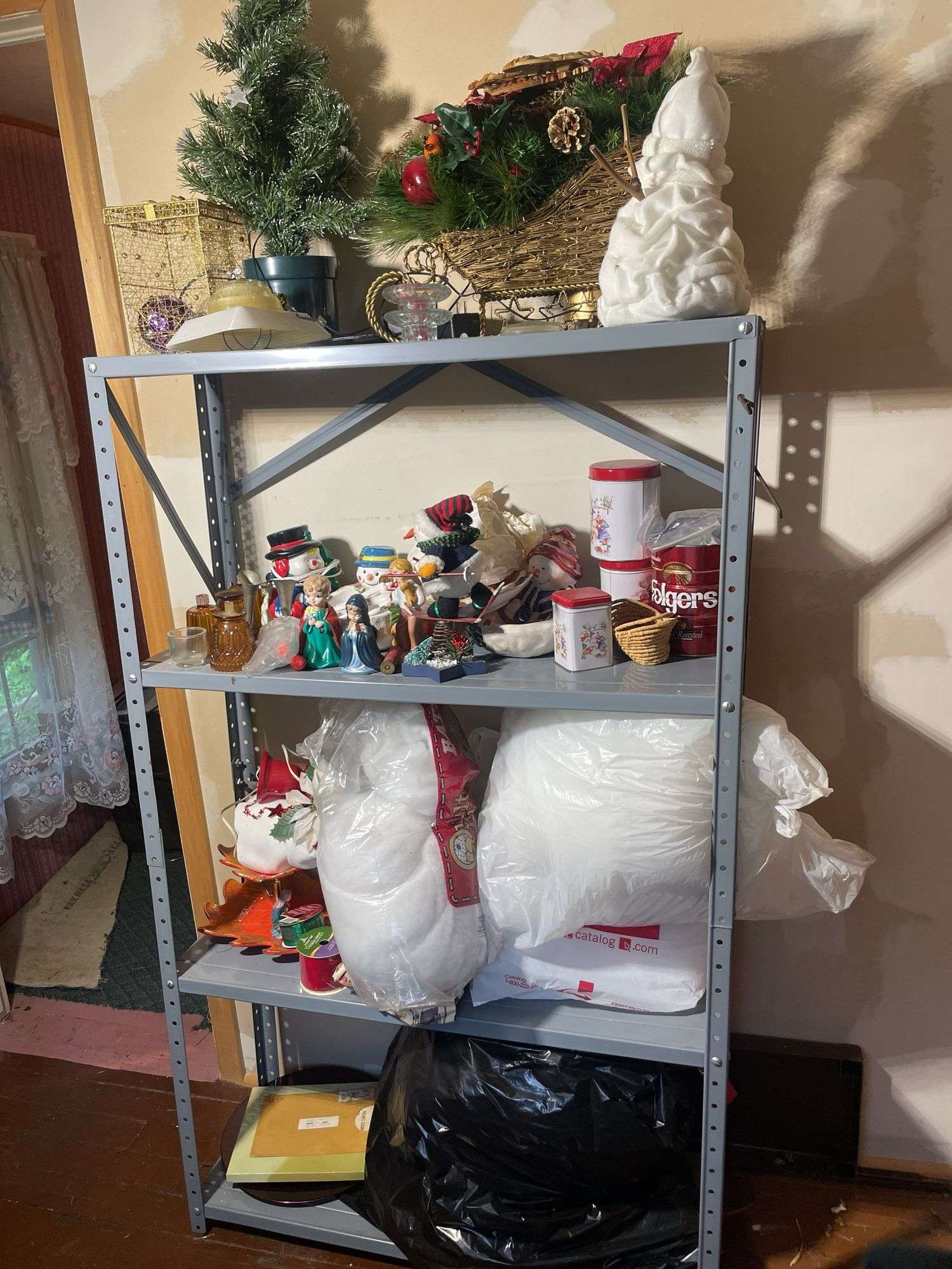 Metal shelf with Christmas decor including decorative sleigh, figurines, stuffing and more