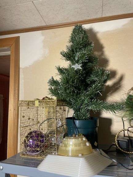 Metal shelf with Christmas decor including decorative sleigh, figurines, stuffing and more