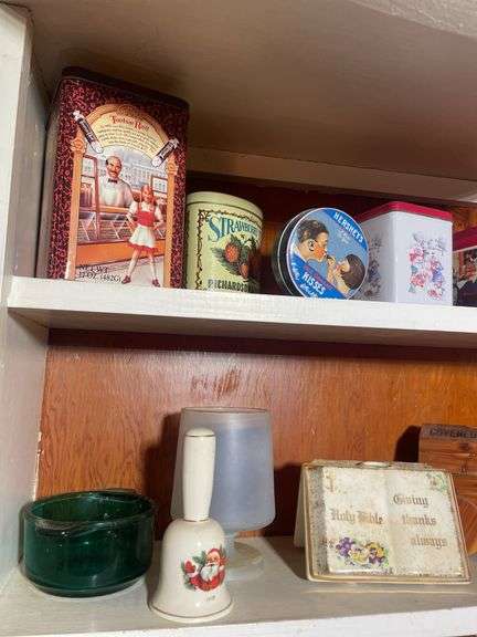 Contents of 2 shelves - including tins, decorative glassware, wooden wagon & more