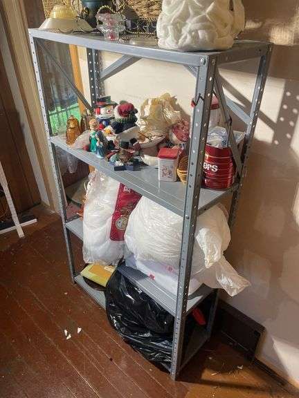 Metal shelf with Christmas decor including decorative sleigh, figurines, stuffing and more