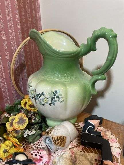 Large lot of glassware & household decor including pitcher, drinking glasses, old baby shoes and mor