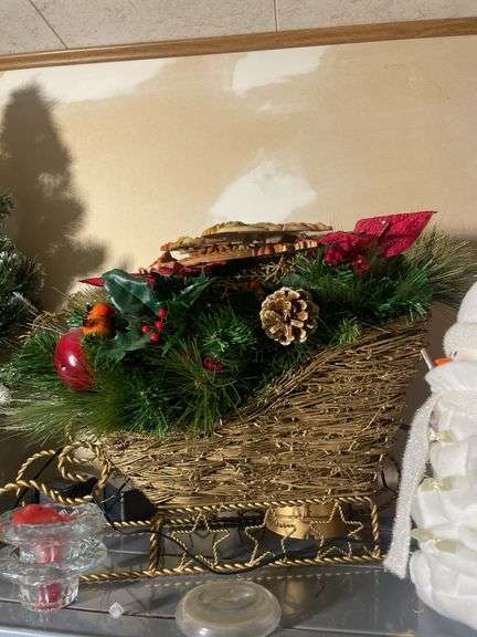 Metal shelf with Christmas decor including decorative sleigh, figurines, stuffing and more