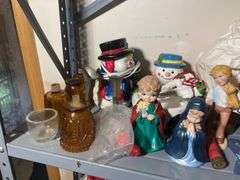 Metal shelf with Christmas decor including decorative sleigh, figurines, stuffing and more