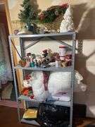 Metal shelf with Christmas decor including decorative sleigh, figurines, stuffing and more