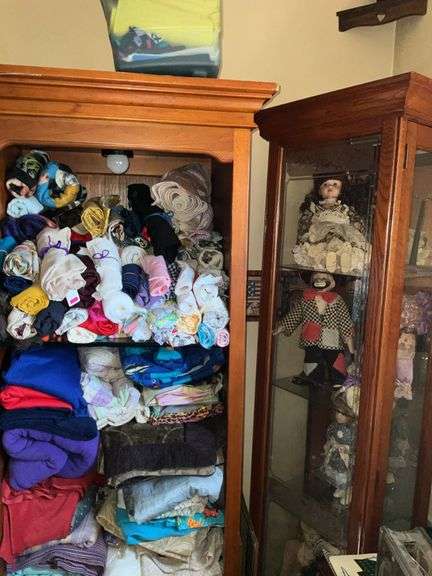 BOOKSHELF AND GLASS SHOWCASE W/ALL DOLLS. BLANKETS, AND FABRIC REMNANTS