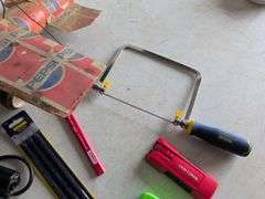Black and Decker drill, Dremel and accessories, saw, staple gun, other tools, and model airplane
