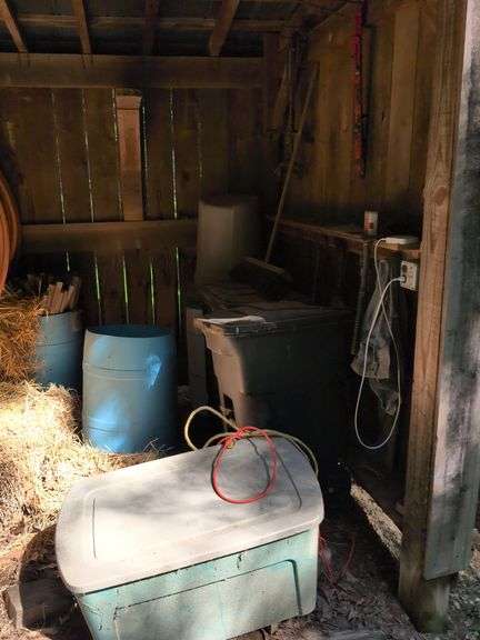 Contents of corner - trash barrels, chains, extension cord, 55 gallon drums, and more