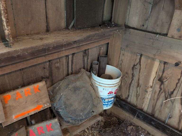 Contents of corner - live animal traps, milk crates, battery charger, and signs