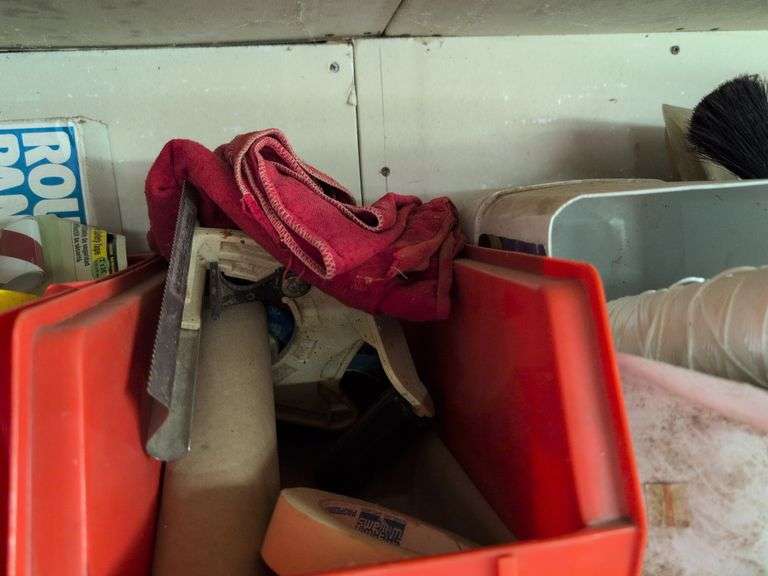 Contents of shelf - staple guns, tape, paint brushes, and more