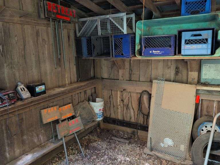 Contents of corner - live animal traps, milk crates, battery charger, and signs