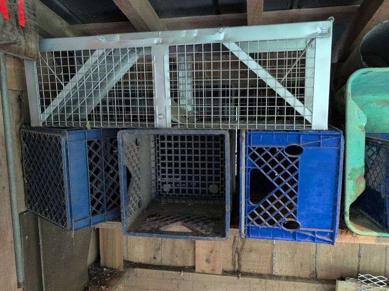 Contents of corner - live animal traps, milk crates, battery charger, and signs