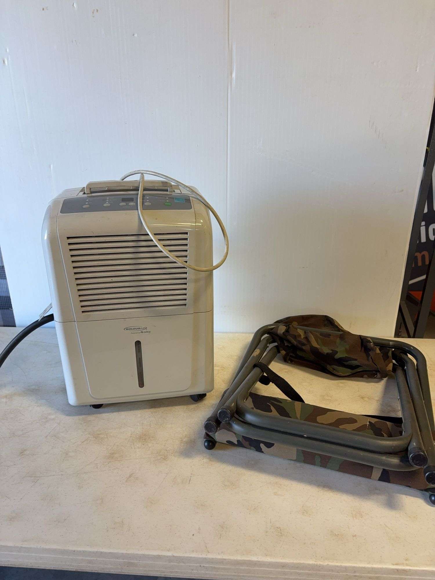 Soleus Air dehumidifier and camo foldable chair