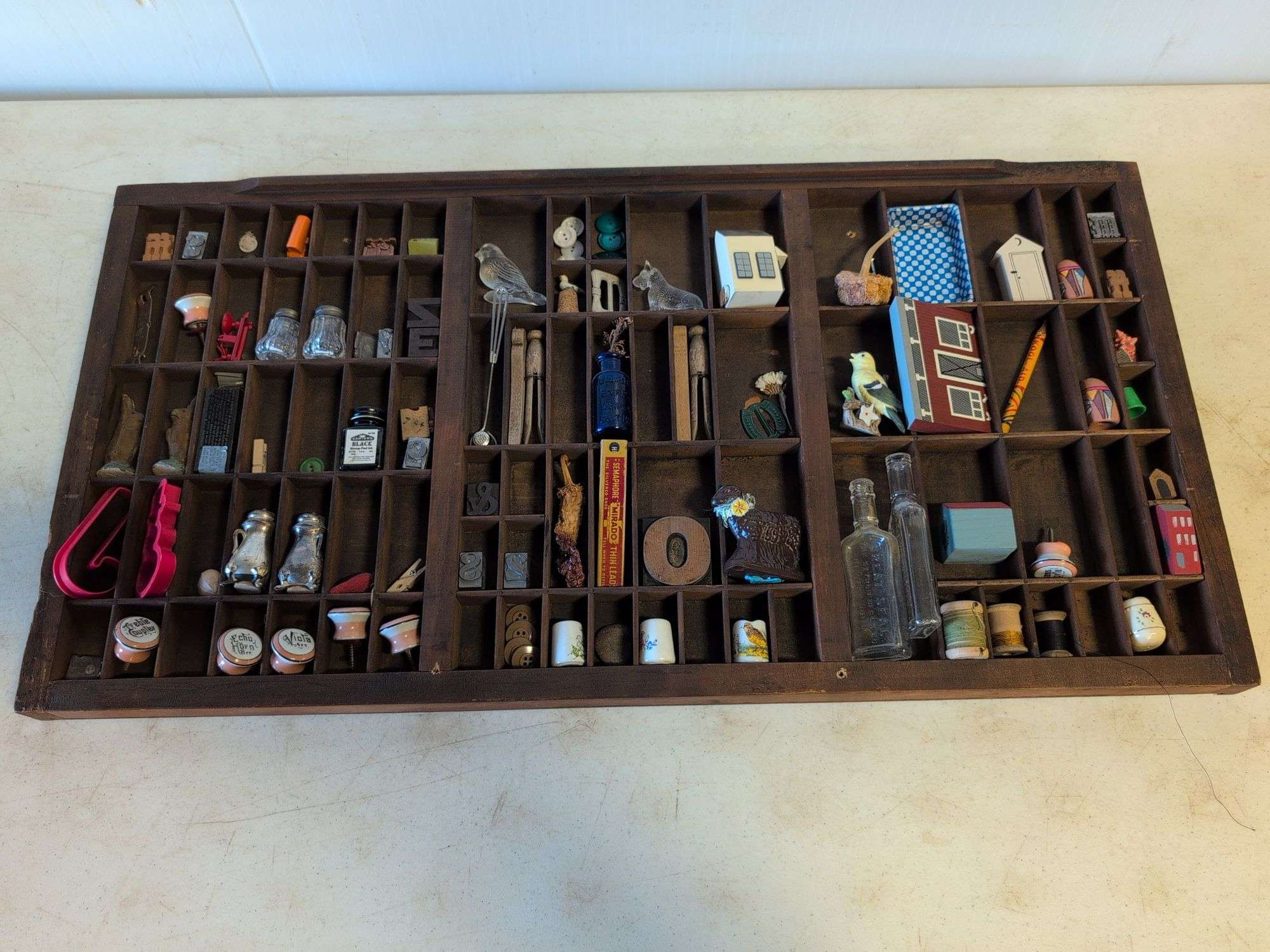 Shadow box with various vintage items - glass figures, print type blocks, and more