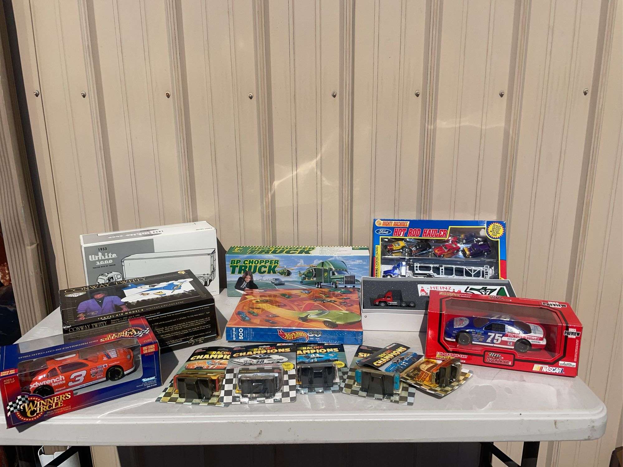 Box of mostly new cars/ toys including hot rod hauler, racing Champions car, BP Chopper Truck and mo