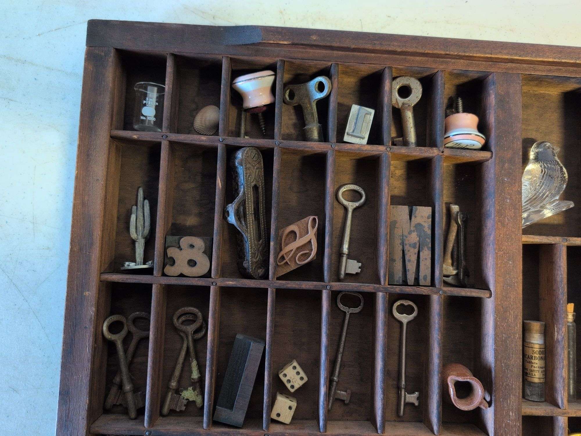 Shadow box with various vintage items - glass figurines, keys, pins, and more