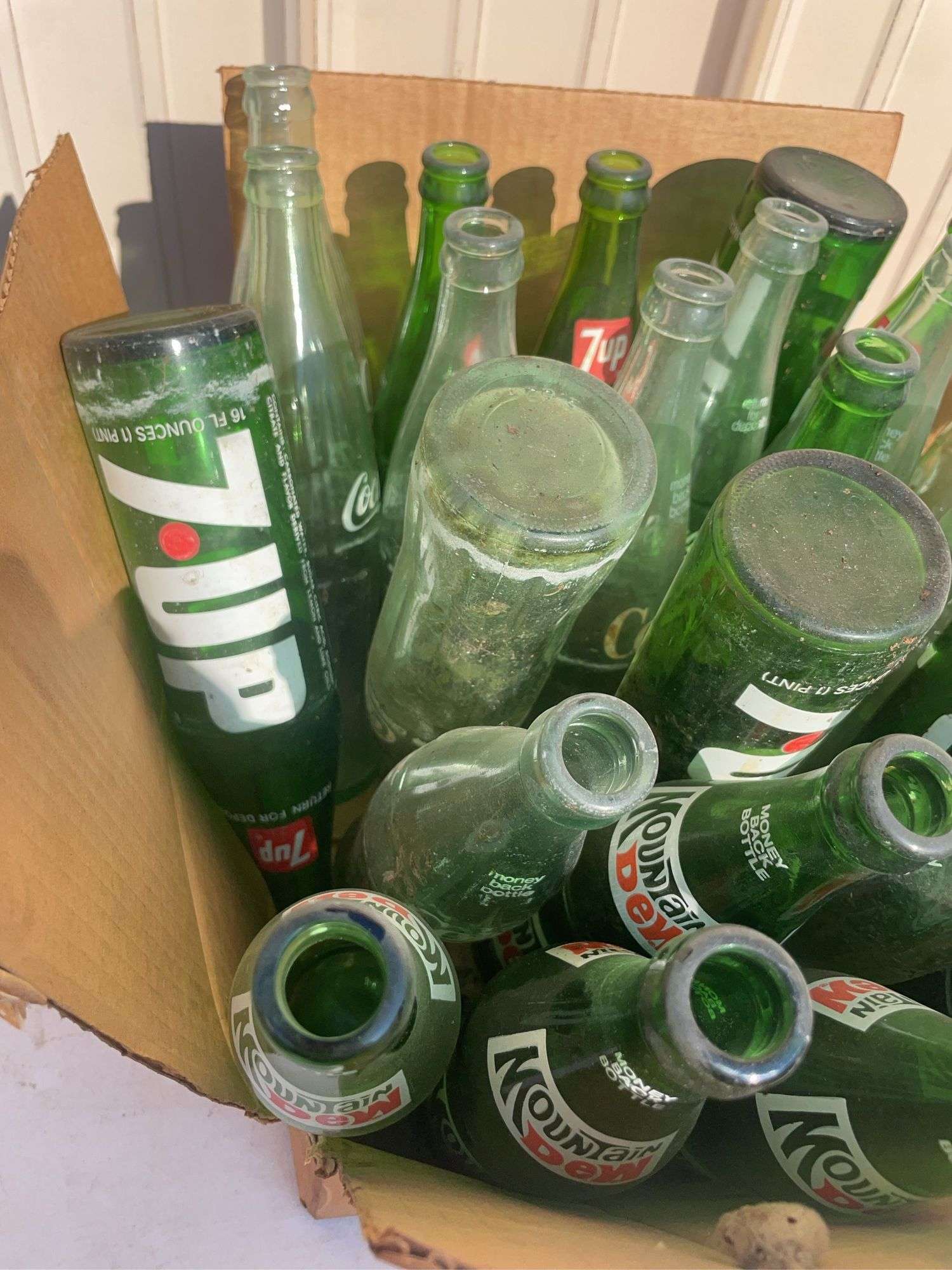 Box of empty 7-up and Mountain Dew bottles