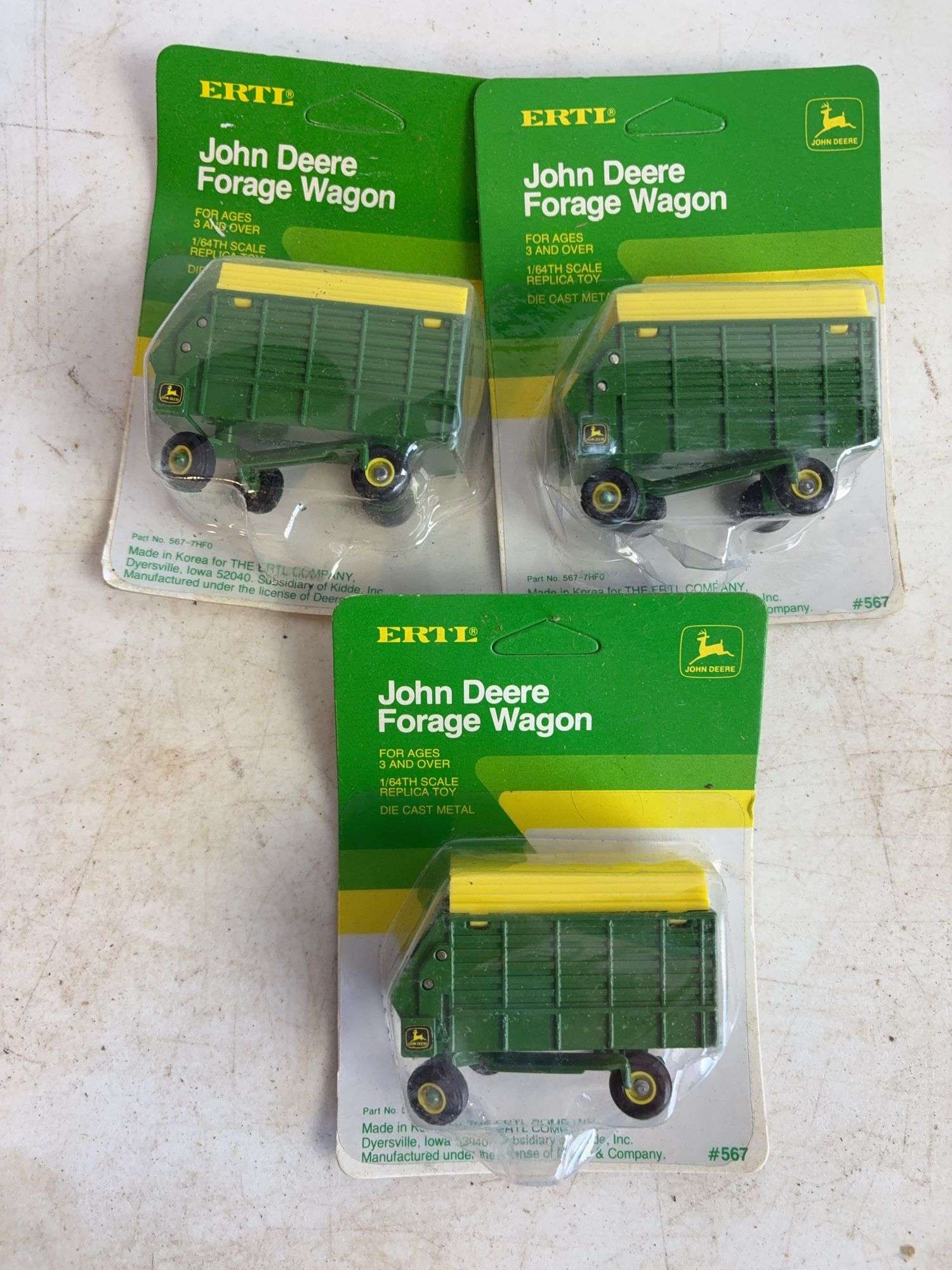 (7) John Deere diecast model toys - (3) forage wagons and (4) round balers