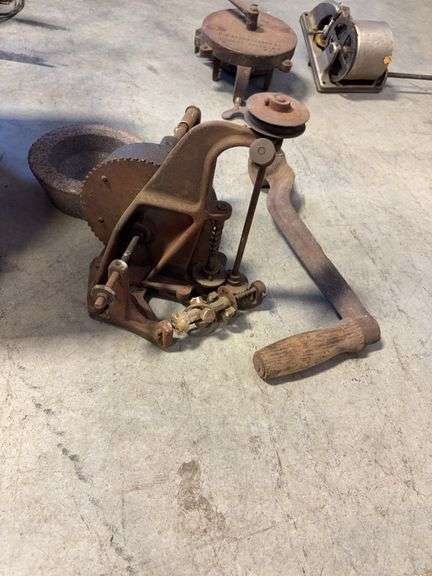 Wooden crate with antique tools - crank grinder, pulley, and more