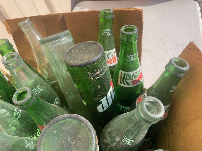Box of empty 7-up and Mountain Dew bottles