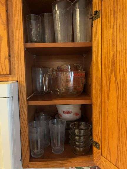Shelves of glass including Pyrex measuring cups and Anchor Hocking bowls