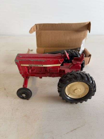 John Deere plate, die-cast model car, and International model tractor