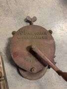 Wooden crate with antique tools - crank grinder, pulley, and more